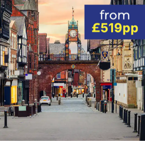 A quiet street scene featuring an archway clock tower, flanked by historic buildings.