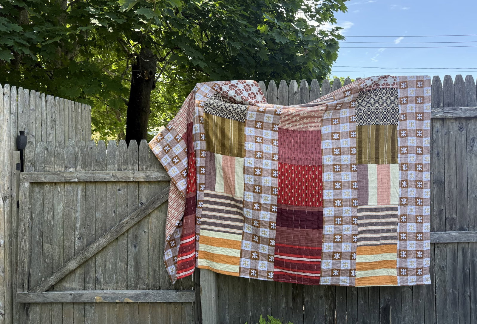 quilt laid across a fence