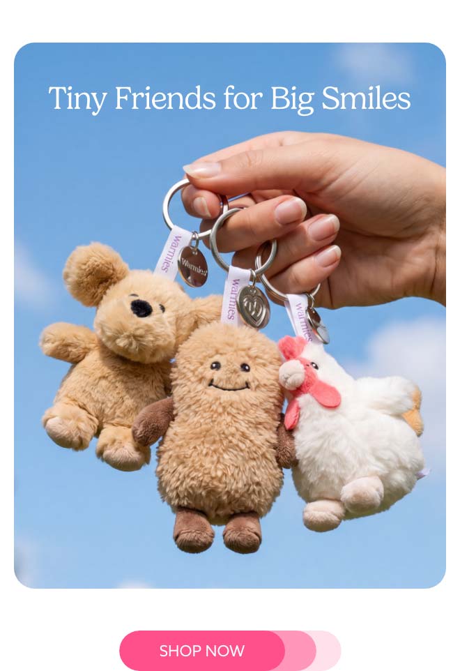 A woman's hand holding up Mini Bag Charms. Shop Now.