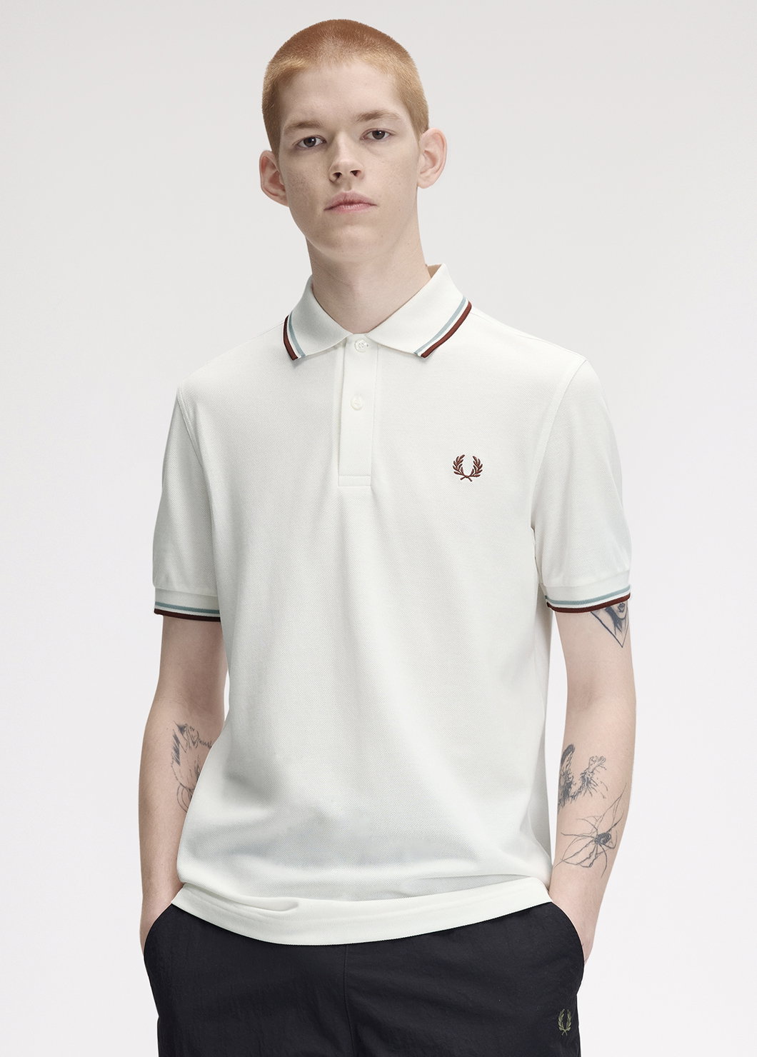 Male model wearing a M3600 Twin Tipped Fred Perry Shirt in Snow White / Silver Blue / Brandy