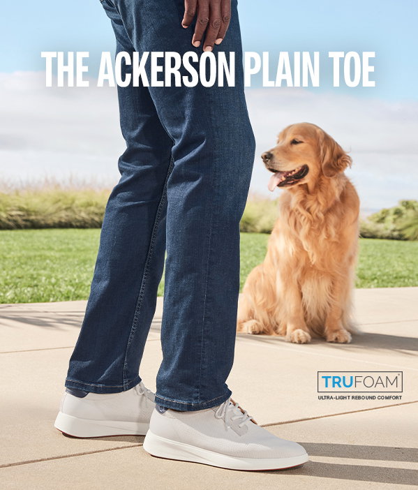 Close-up of the Ackerson Plain Toe sneaker worn with jeans as a golden retriever sits in the background. Text reads: 