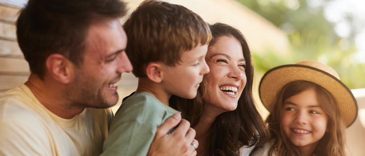 Familie mit zwei Kindern verbringt gemeinsam eine fröhliche Zeit im Freien.