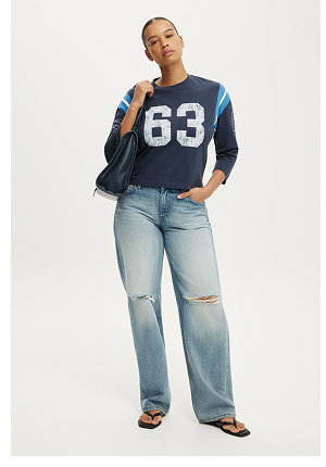 Woman wearing navy sports-style shirt with "63" graphic 