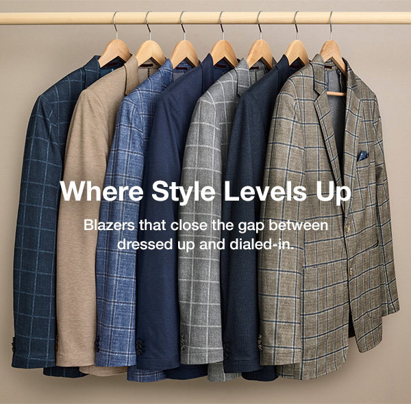 Assortment of men's blazers in solid colors and windowpane patterns hanging on a clothing rack. Text reads: 