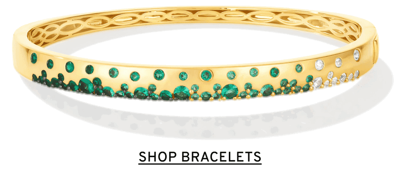 A gold and emerald bangle. Click to Shop Bracelets