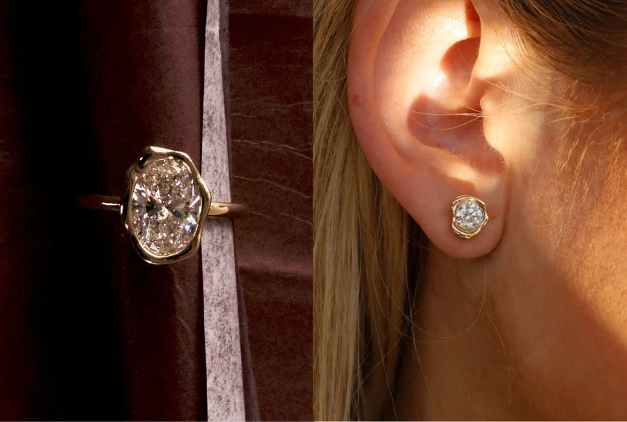 Flat lay of abstract bezel engagement ring against a maroon textured background, next to a close up of woman's ears showcasing large abstract bezel diamond studs