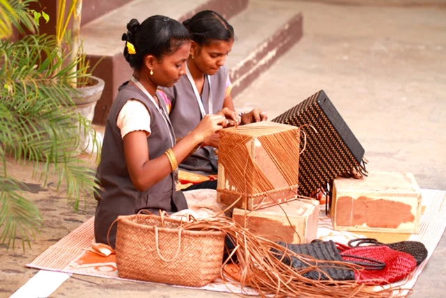 alt="women weaving basket bags"