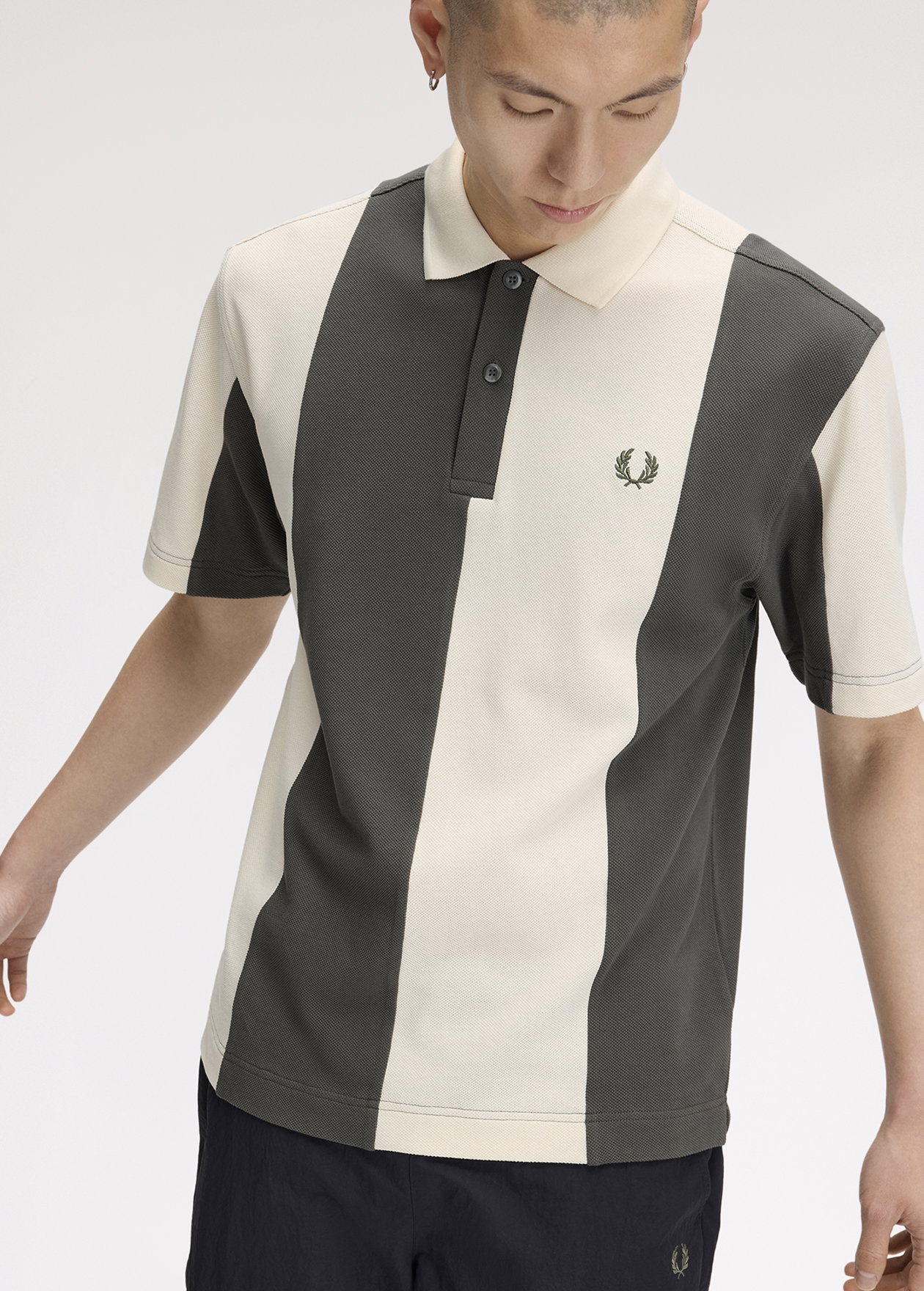A male model wearing a Fred Perry Panelled Polo Shirt in Ecru