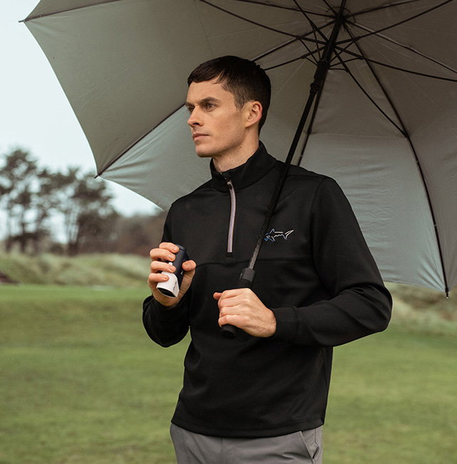 Golfer holding an open umbrella