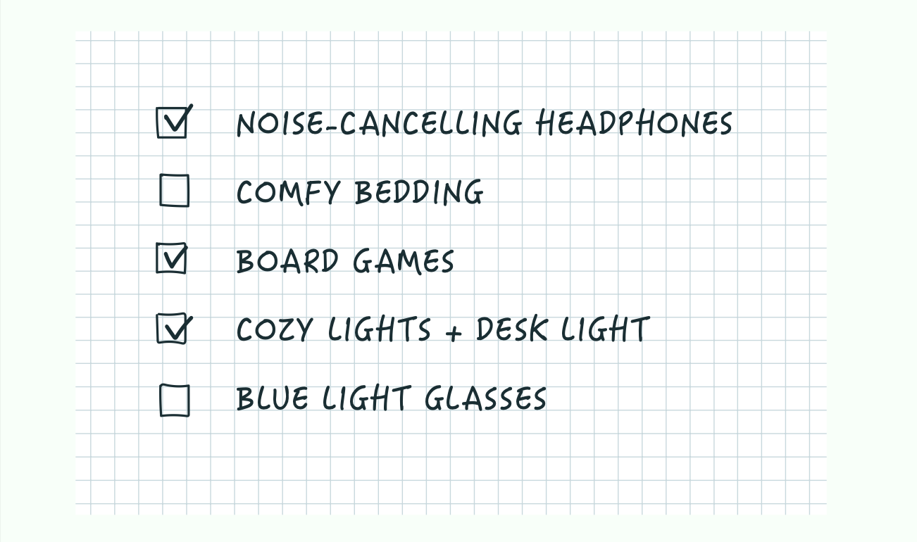A handwritten-style dorm room essentials checklist on graph paper shows checked items for noise-cancelling headphones, board games, and cozy lights with a desk lamp, while comfy bedding and blue light glasses remain unchecked.