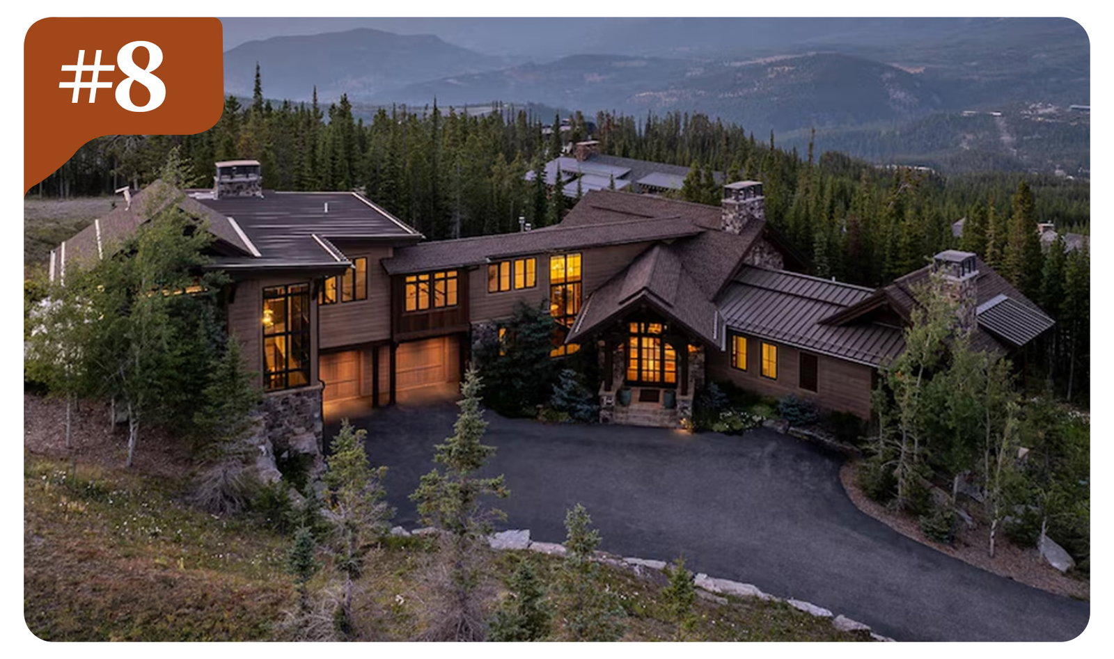 Sprawling alpine lodge perched above the valley, framed by rugged peaks and sweeping views.