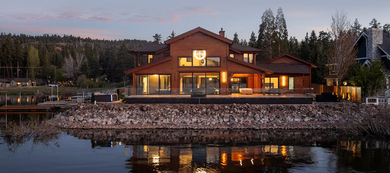 Lakefront home with expansive views, inviting outdoor spaces, and tranquil reflections at dusk.