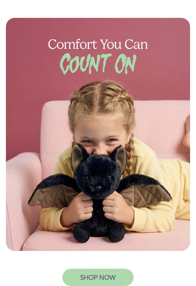 A little girl hugging Bat Warmies. Shop Now.