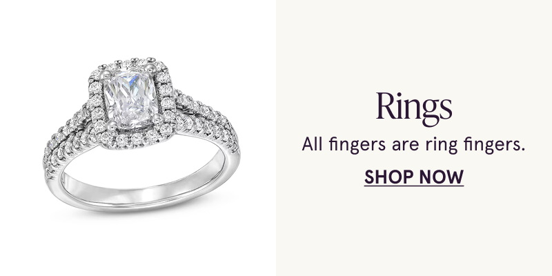 A white metal ring with an emerald cut center stone. All fingers are ring fingers. Click here to shop rings