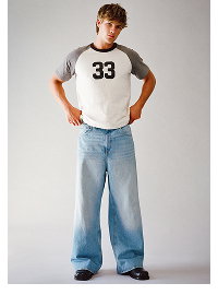 Male model wearing grey and white raglan tee and blue jeans