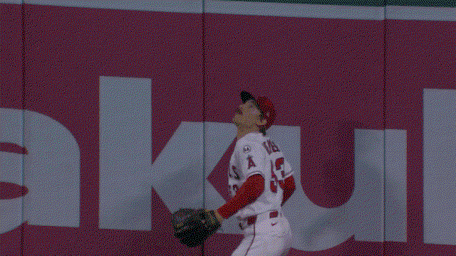 An animated gif of Wade Meckler leaping to reach high over the wall to rob a home run