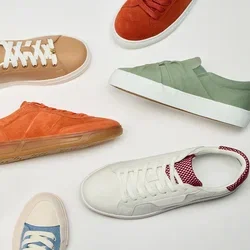 Gevarieerde casual sneakers in beige, oranje, groen, wit met rode accenten, roze en blauw gerangschikt in een cirkel op een witte achtergrond.