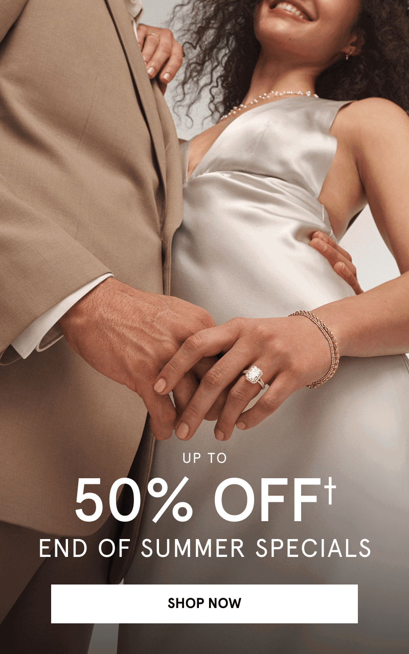 Couple embracing, showcasing a diamond engagement ring. Up to 50% off end of summer specials. Click shop now.
