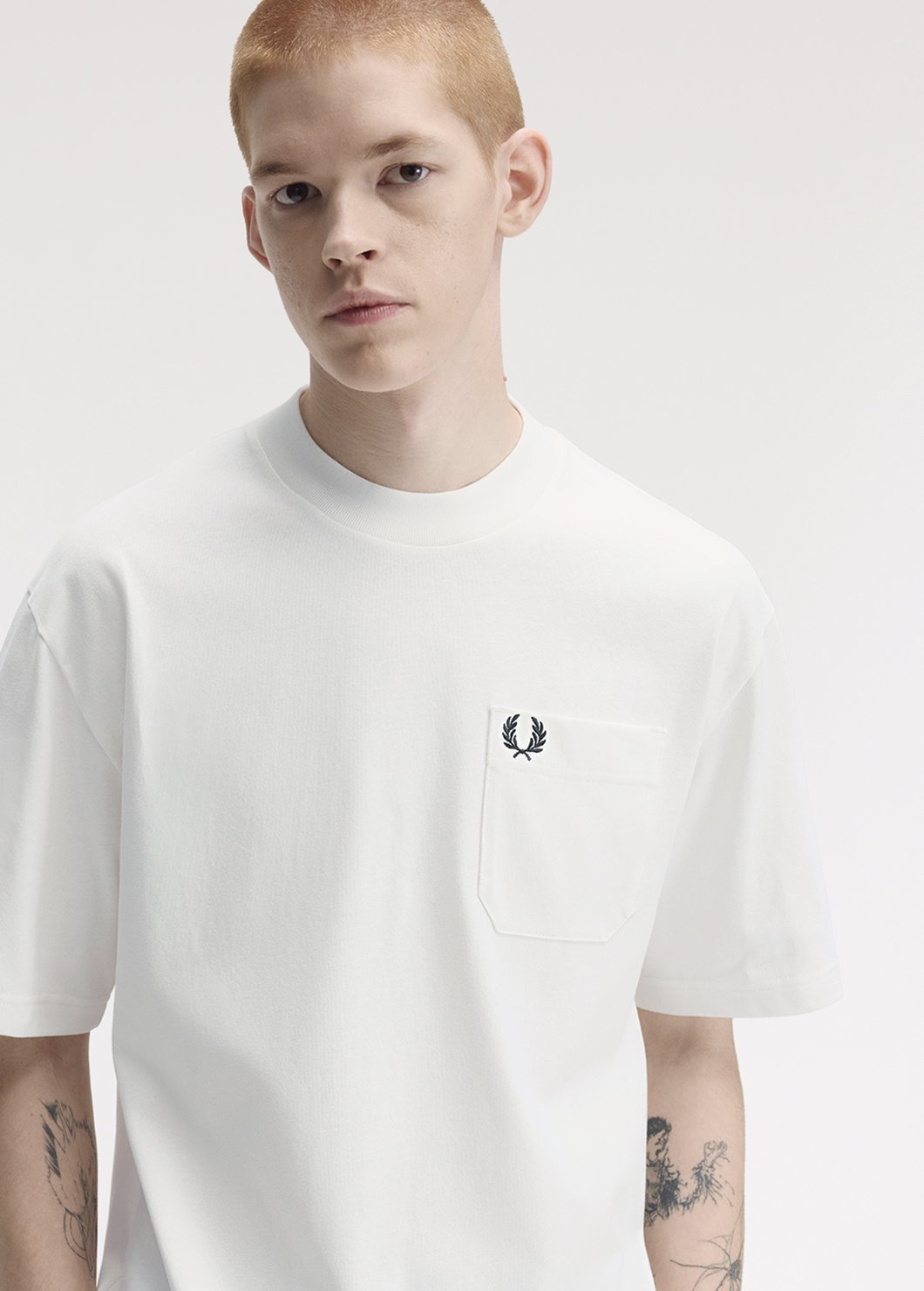 A male model wearing a Fred Perry Relaxed T-Shirt in Snow White