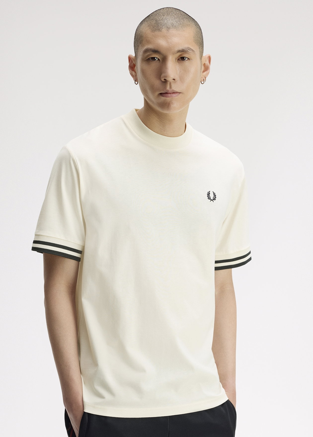 A male model wearing a Fred Perry Relaxed Fit Bold Tipped T-Shirt in Ecru