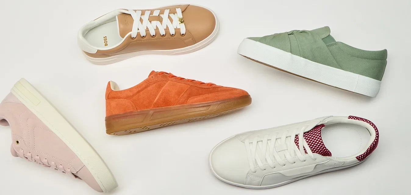 Verschiedene lässige Sneakers in Beige, Orange, Grün, Weiß mit roten Akzenten, Rosa und Blau, die im Kreis auf einem weißen Hintergrund angeordnet sind.