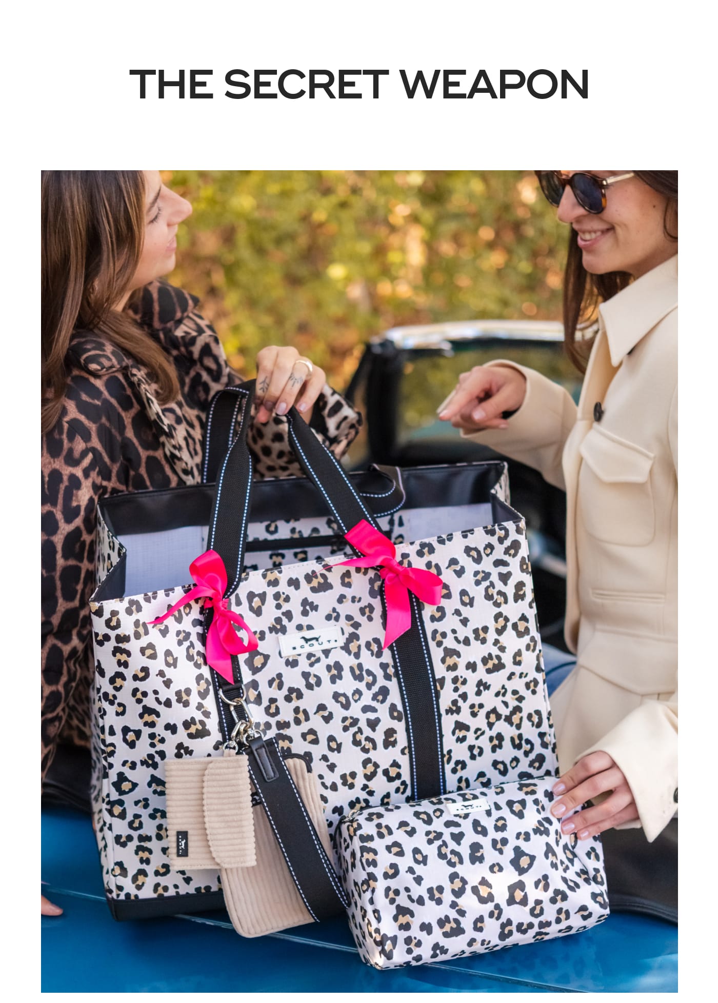 THE SECRET WEAPON. Two women looking at a SCOUT leopard print tote bag.