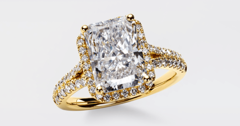 A radiant-cut diamond ring in yellow gold with a diamond halo and pavé band.