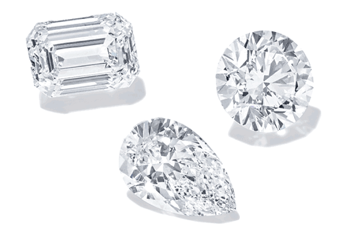 Emerald, round and pear-shaped loose diamonds floating.