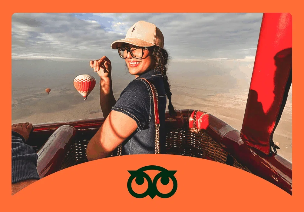 Image description: Young woman smiling on a hot air balloon ride with sun shining on her face, photo taken by @776asmaae