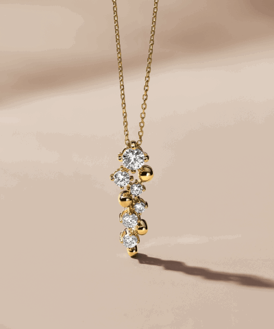 Yellow gold pendant necklace featuring a cluster of round clear stones.