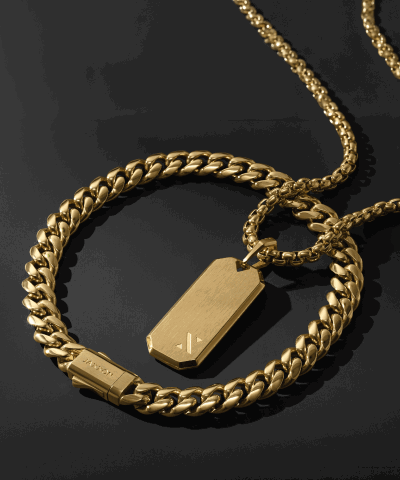 Yellow gold Jaxxon curb chain bracelet and matching chain necklace with a rectangular tag pendant. Click shop now.