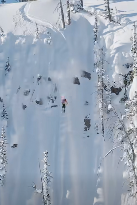 Skier riding down steep line