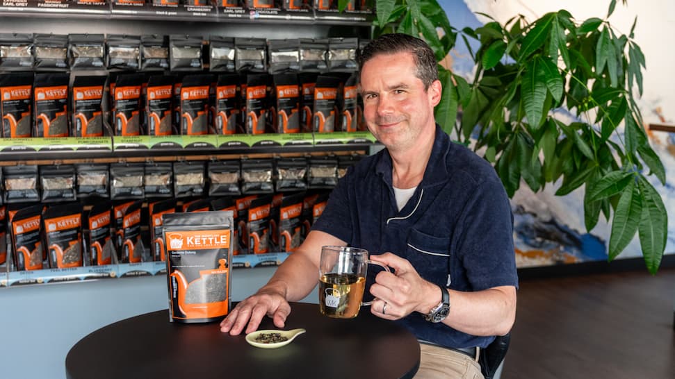 WK COFounder Kevin smiling holding a cup of gardenia oolong tea