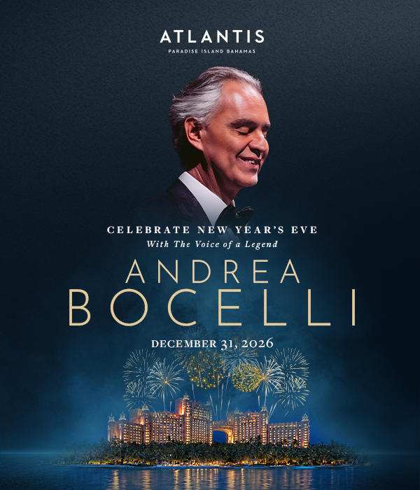 Andrea Bocelli standing with The Royal at Atlantis Paradise with fireworksas background.