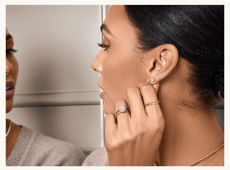 Model with diamond studs, halo ring, stacked delicate ring & layered necklaces.