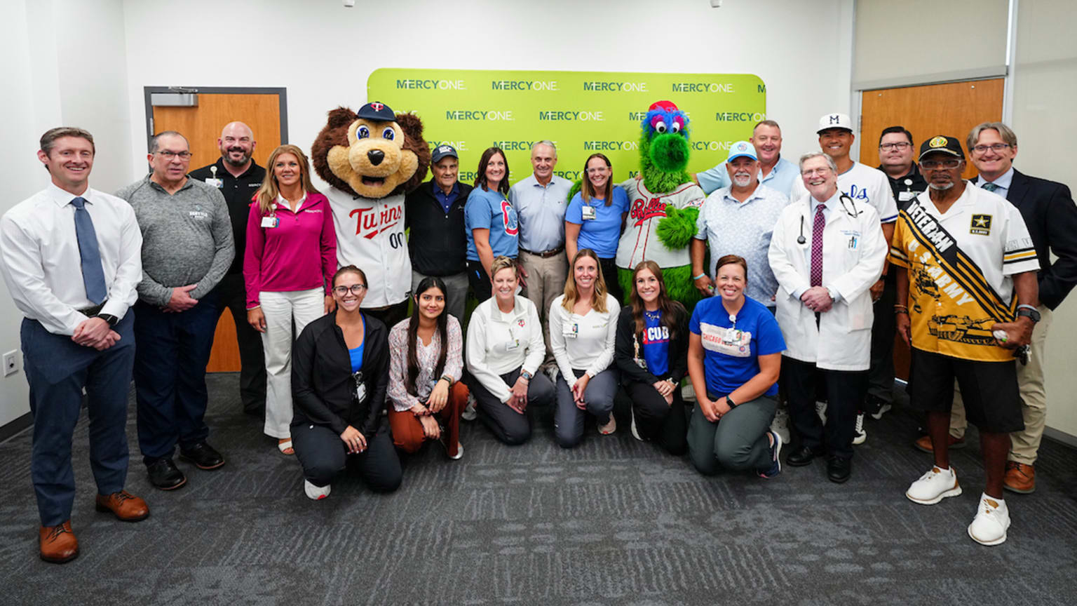 Cancer patients and staff members gather for a photo with Hall of Famers and Twins and Phillies mascots