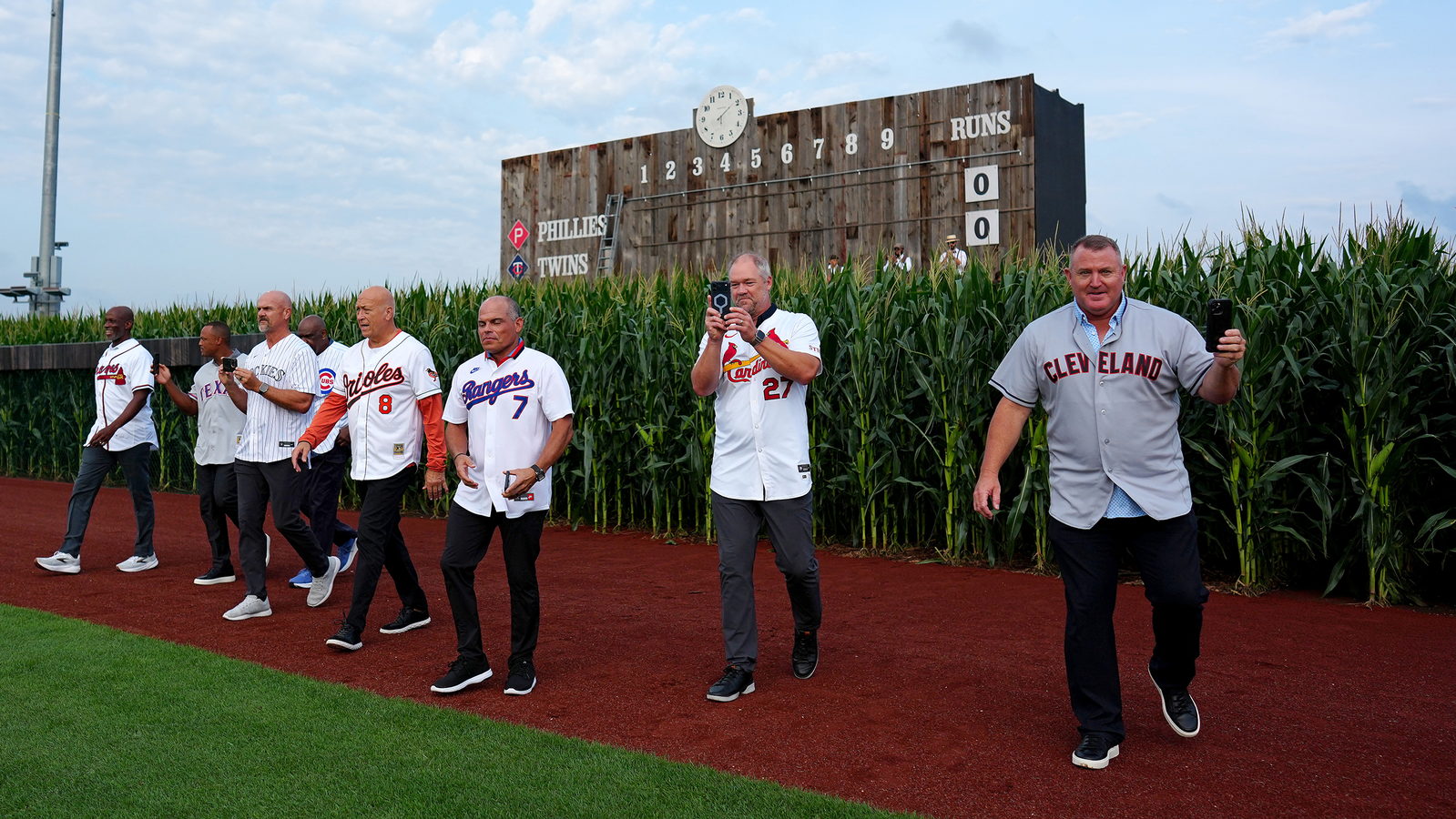 Hall of Famers walk out of the corn at the Field of Dreams Game
