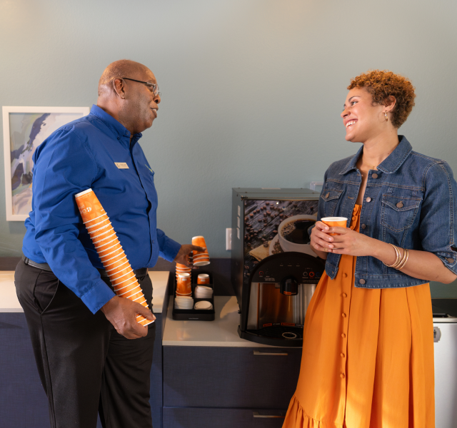 A WoodSpring Suites General Manager shares a laugh with a guest