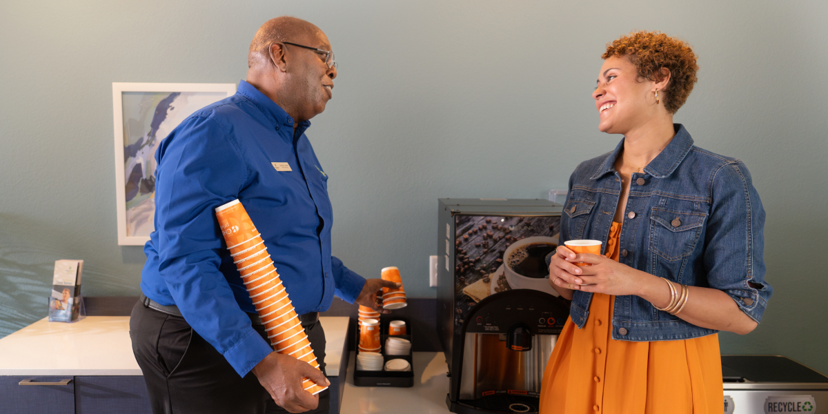 A WoodSpring Suites General Manager shares a laugh with a guest