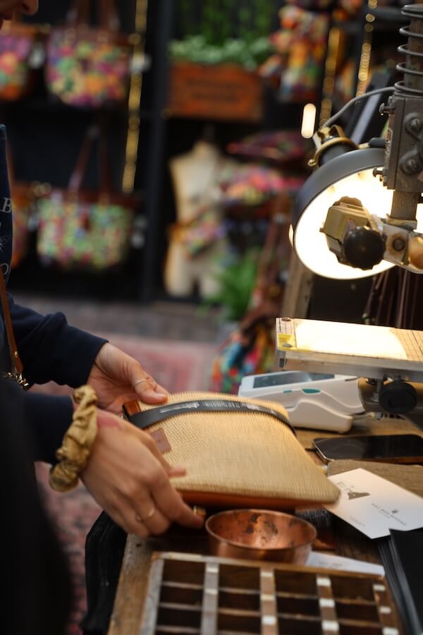 George gift wrapping a raffia clutch bag