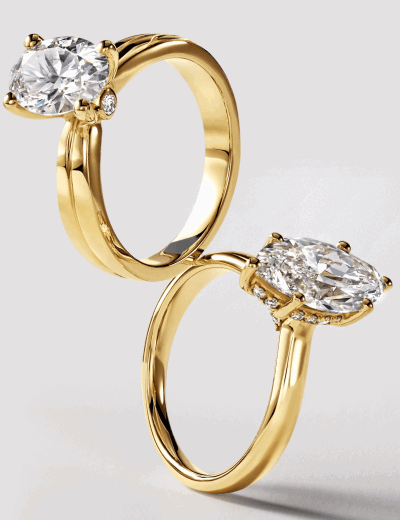 Two marquise diamond rings in yellow gold with solitaire and halo settings.