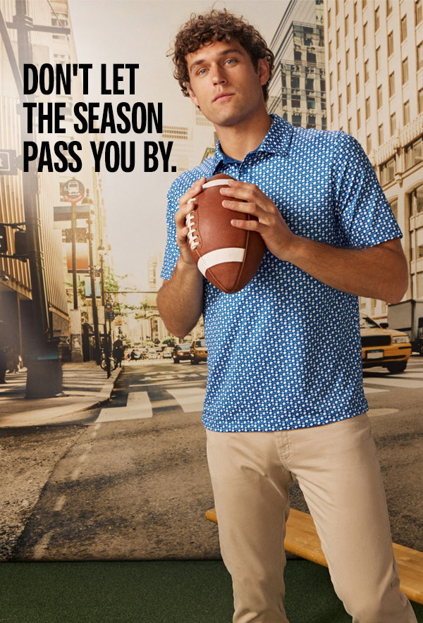 Model wearing a blue football-print polo and khaki pants while holding a football against a city backdrop. Text reads: 