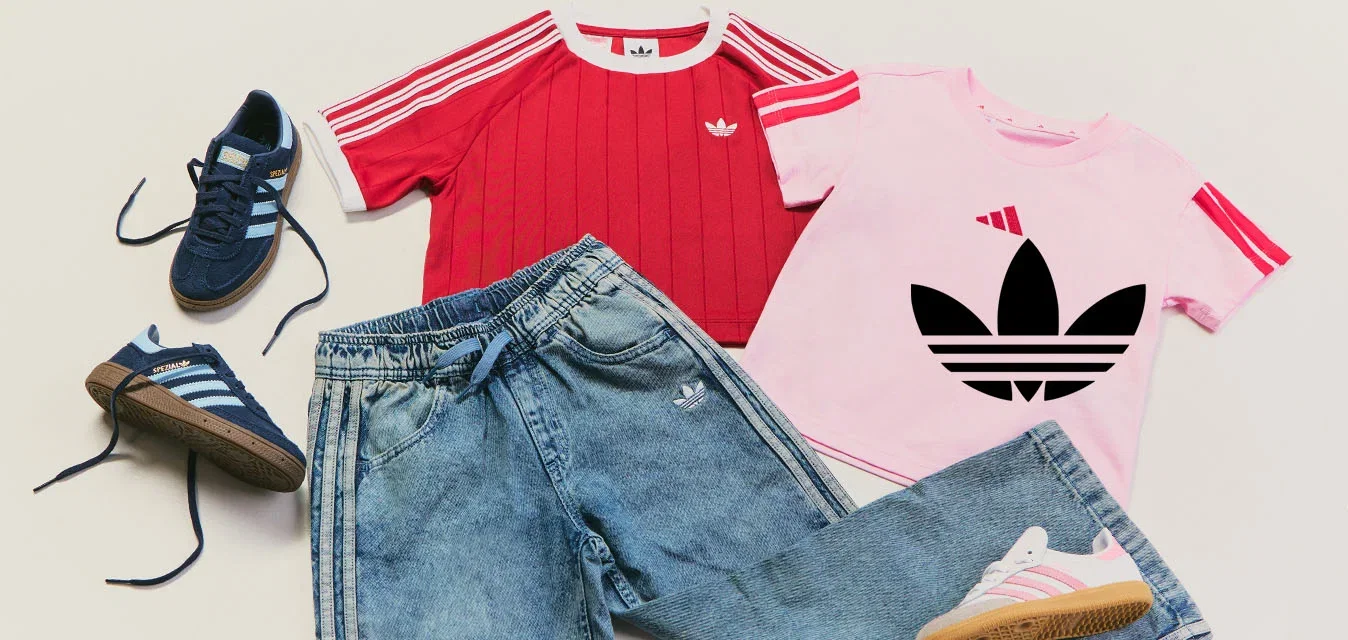 Zwei Paar Adidas-Sneakers, blau und weiss mit pink, daneben zwei kurzärmelige Shirts, rot und pink, und eine blaue Adidas-Jeans.