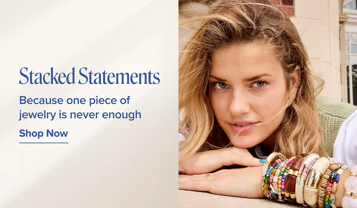Stacked statements. Because one piece of jewelry is never enough. Shop the trend. A woman wearing a stack of bracelets.