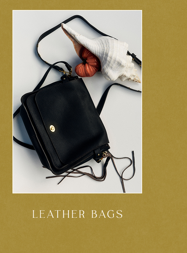 Black pebbled leather crossbody bag with fringe accents displayed alongside a white conch shell on a mustard background. Text: LEATHER BAGS.
