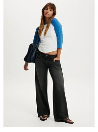 Woman wearing blue cardigan, white top, and black wide-leg pants