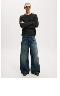 Man wearing black long-sleeve shirt and wide-leg denim jeans