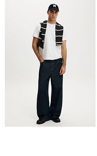 Male model wearing white t-shirt, striped vest and black pants