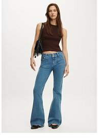 Woman wearing brown sleeveless top and blue flare jeans