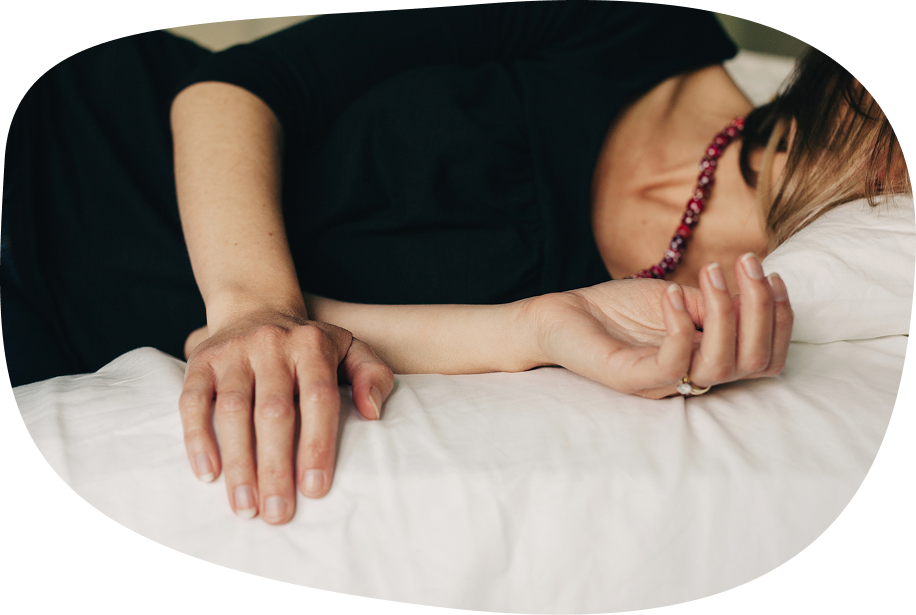 Person lying in bed with a migraine